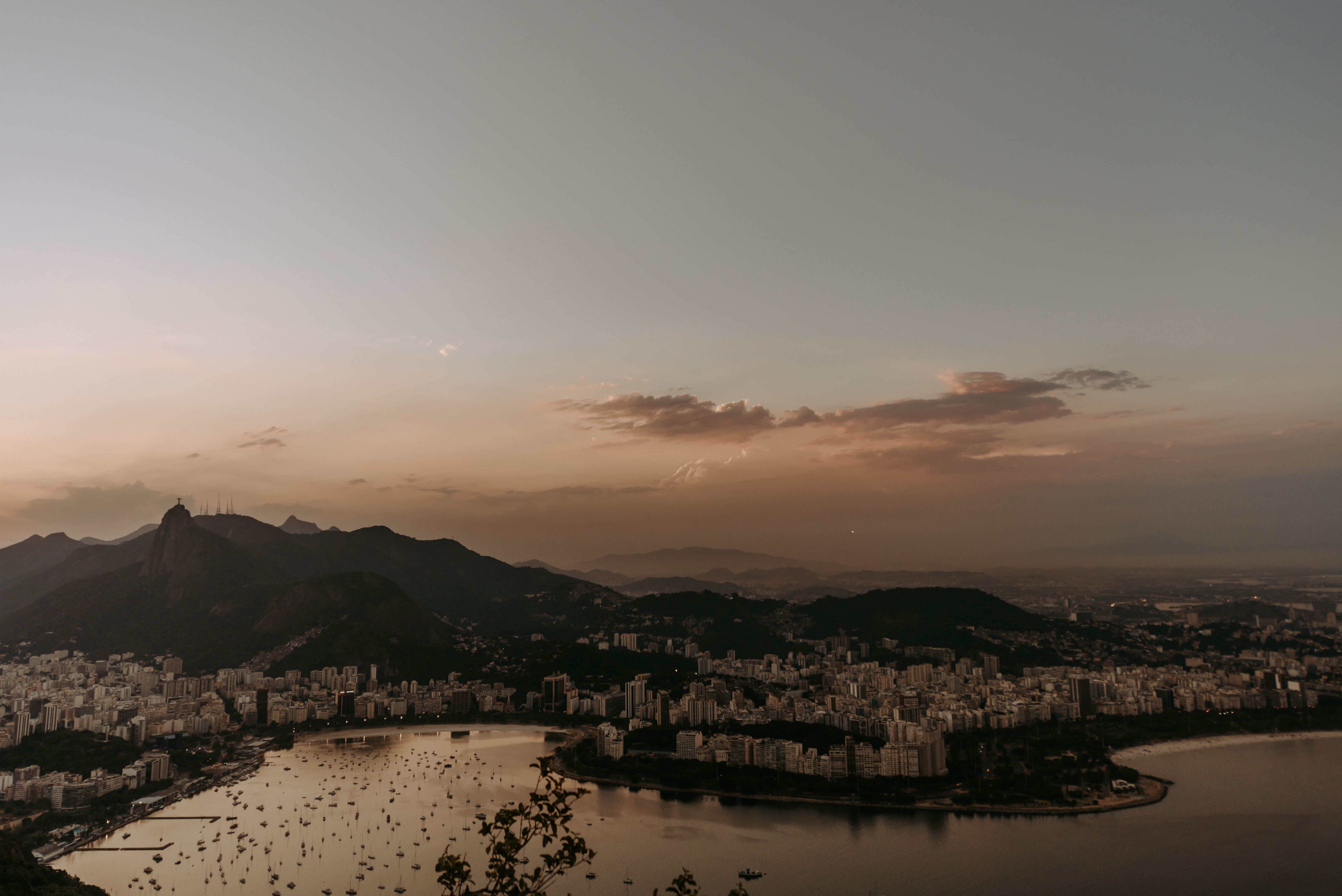 Unbeatable Rio : Helicopter tour at Christ the Redeemer - 30 minutes Review Review 2026 - Breathtaking aerial view of Rio de Janeiro's skyline at sunset with the iconic Christ the Redeemer in view.