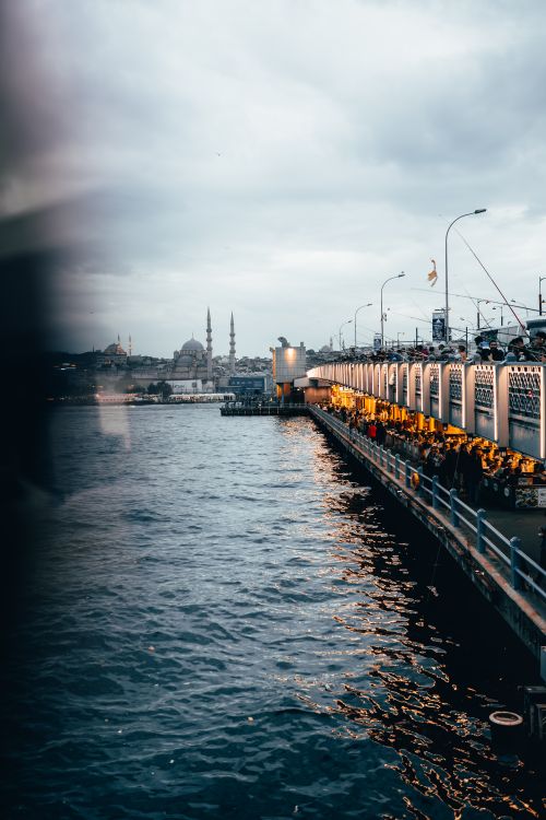 Free Mesmerizing Istanbul cityscape featuring the bustling Galata Bridge over the water at dusk. Stock Photo