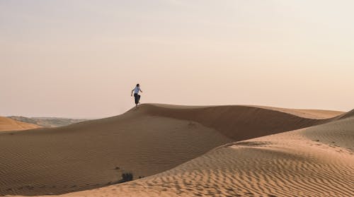 Free Person Walking on Desert Sand Stock Photo