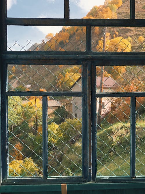 View of Houses on Mountainside from Window Steel Frame with Wire Mesh 