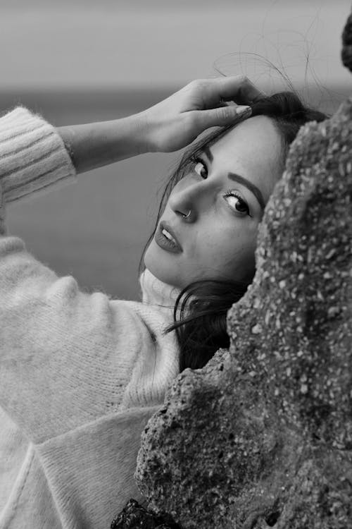 Grayscale Photo of a Woman Leaning on a Wall