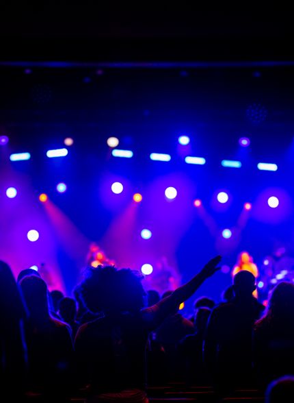 Stage lights over a raised hand — photo by Caleb Oquendo on Pexels