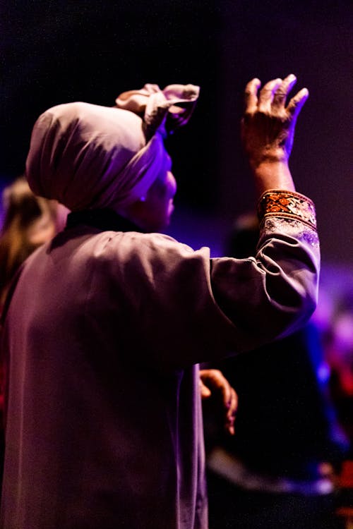 A Woman Wearing Headscarf Raising Her Hand