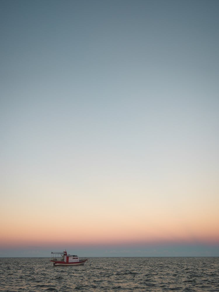 Small Fishing Boat On Sea At Sunrise