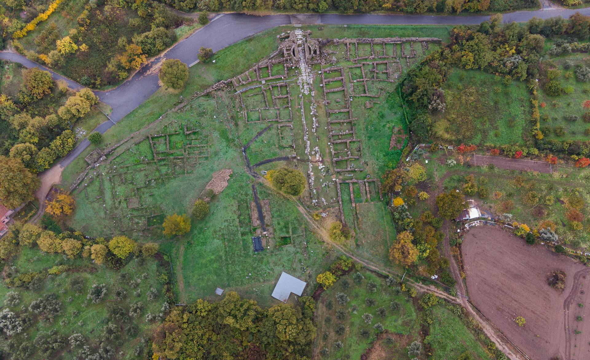Discover the ancient ruins nestled in the lush countryside of Greece from a breathtaking aerial perspective.