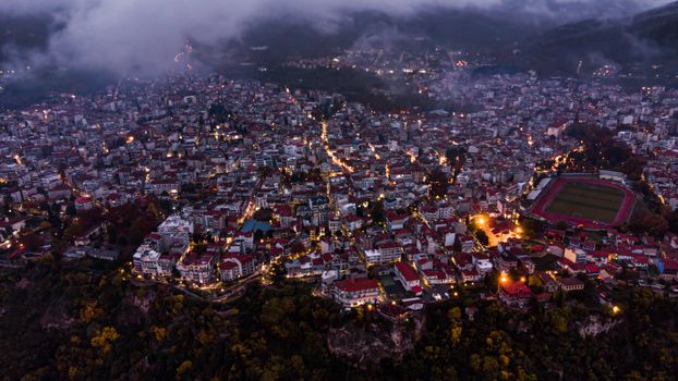 Aerial night view of Edessa, Greece, showcasing city lights and architecture.
