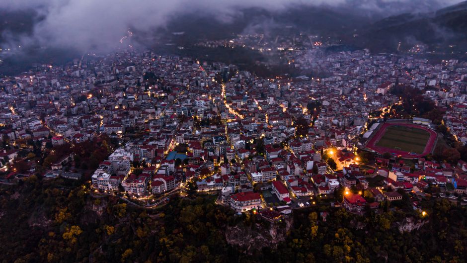 Amazing Santorini 20 Minute Helicopter Ride and Wine Tasting Experience Review 2026 - Aerial night view of Edessa, Greece, showcasing city lights and architecture.