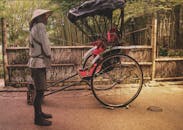 在日本京都风景优美的小路上，人力车司机等候着，展示着传统文化