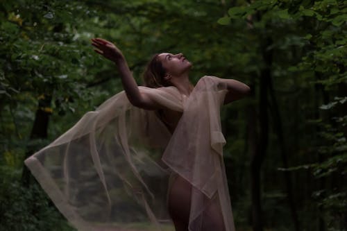 Woman Covering Her Body with Sheer Fabric Posing Beautifully