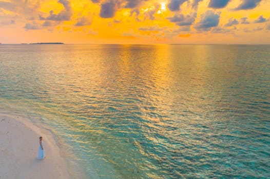 一位新娘站在宁静的马尔代夫海滩上，在日落时分，映衬出平和与美丽