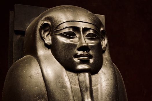 Close-up view of an ancient Egyptian pharaoh statue highlighting intricate details.