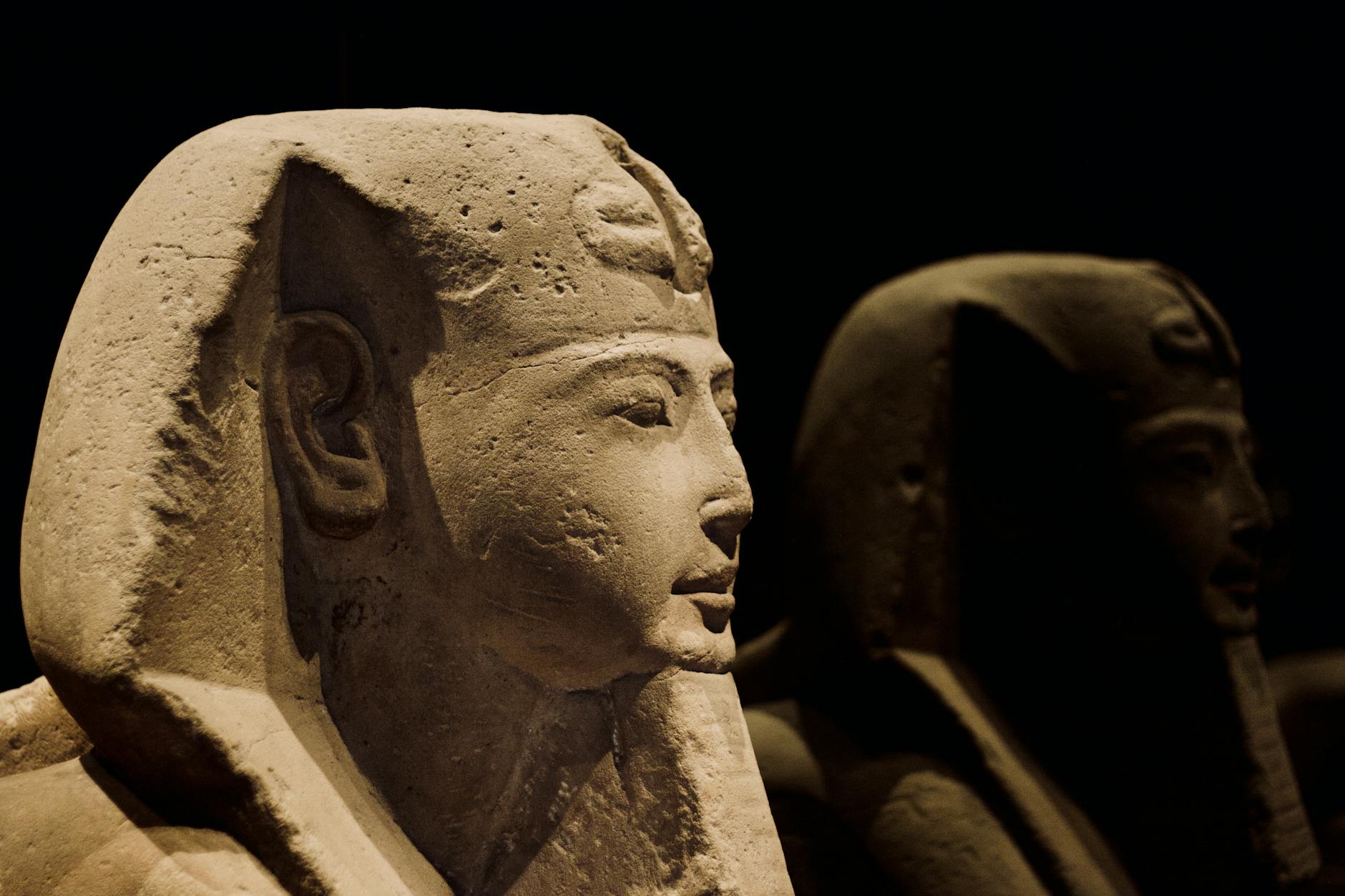 Close-up of ancient Egyptian statues depicting pharaohs with intricate details.