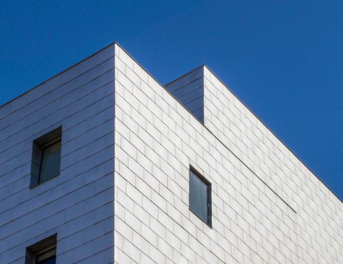 Free Low angle view of a modern building's facade with glass windows against a blue sky in Minneapolis. Stock Photo