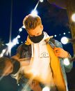 A Man Wearing a Denim Jacket and a Neck Gaiter