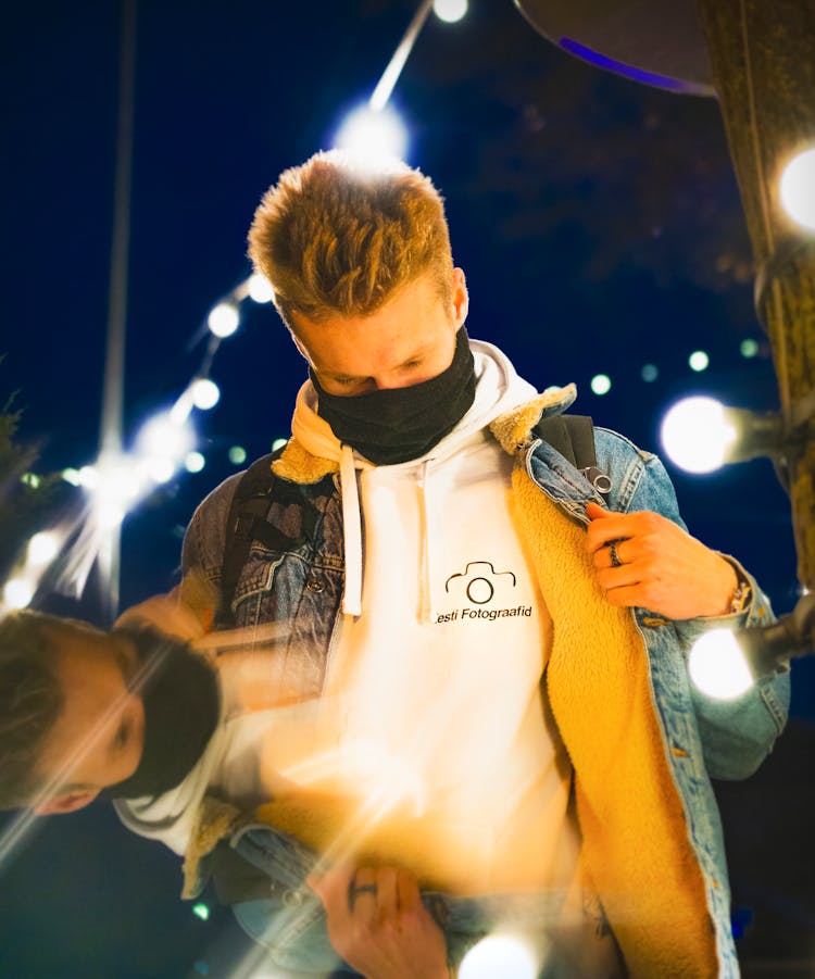 
A Man Wearing A Denim Jacket And A Neck Gaiter