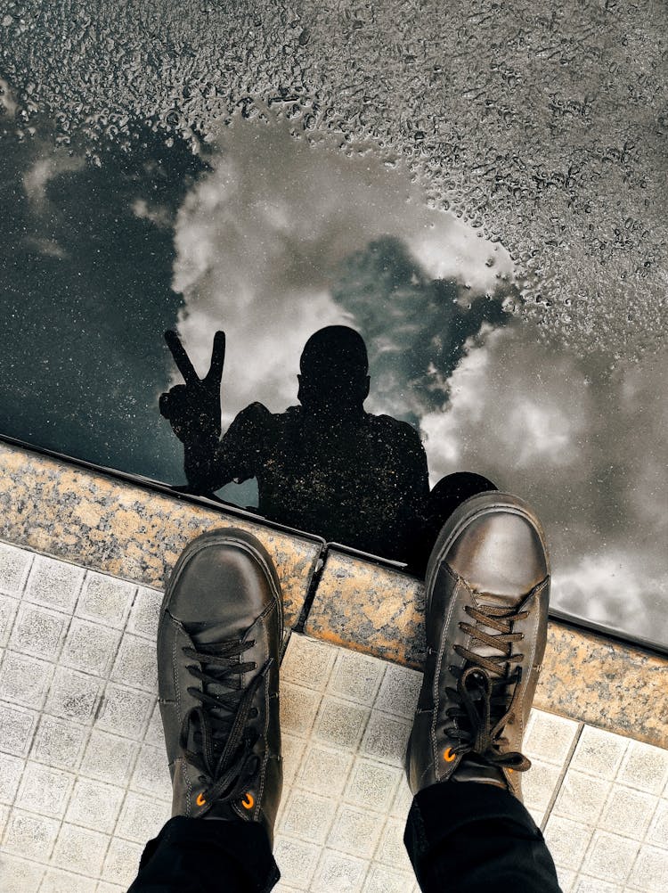 Silhouette Of Person Reflecting In Puddle