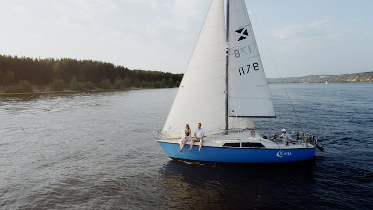 A Couple Sitting On A Sailboat