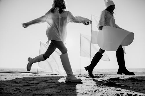 Women Walking over Puddles on Shore
