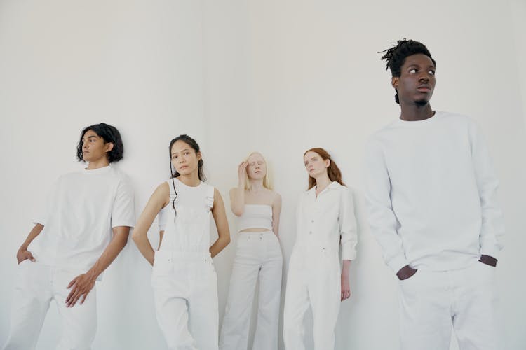 Group Of People Standing Near White Wall