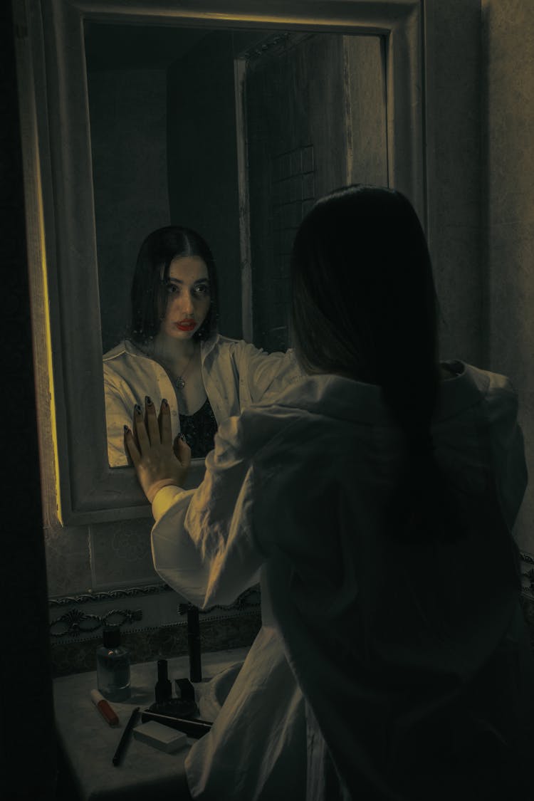 Woman With Red Lips Staring At Herself On A Mirror