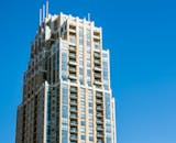 一座拥有现代外观的摩天大楼，在晴朗的蓝天下显得格外引人注目