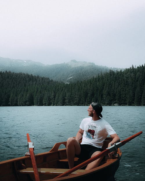 Man Sitting in Boat on Lake