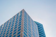 低角度视角下的现代摩天大楼，反光玻璃窗映衬着晴朗的天空