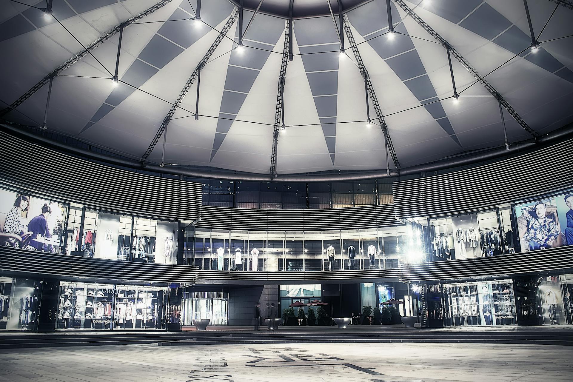 Explore the sleek, modern architecture of a Beijing shopping mall with glass facades and a geometric ceiling.