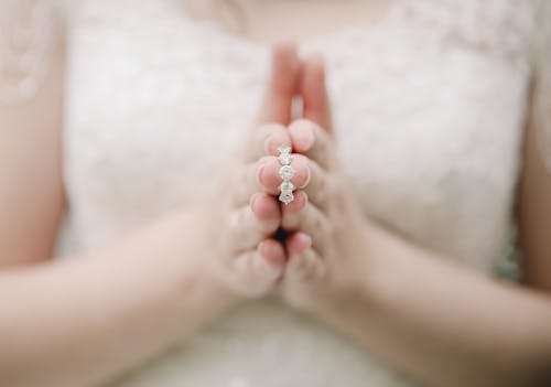 Free Person Wearing White Lace Dress Holding a Ring with Diamonds Stock Photo