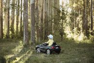 Little Boy in Hat Driving Toy Car in Forest