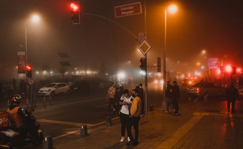 Free A moody, foggy night scene in Üsküdar, Istanbul, with people and vehicles under streetlights. Stock Photo