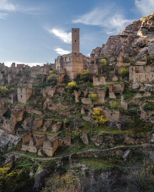 Free Explore the captivating ancient ruins on a rocky hillside, showcasing historical architecture under a bright blue sky. Stock Photo