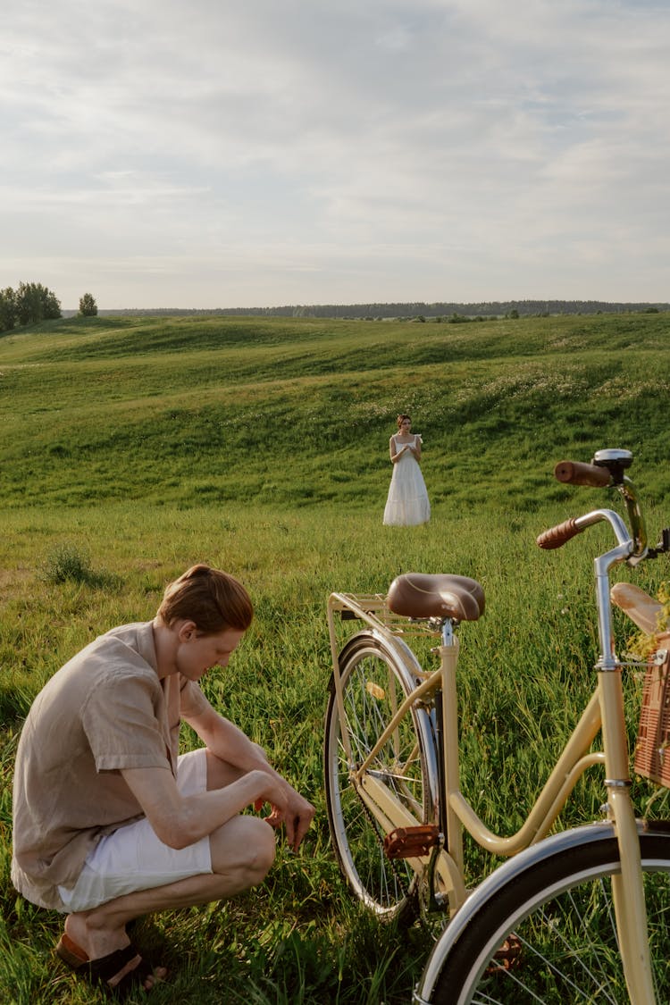 Man Crouching Beside A Bicycle