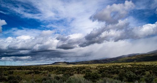 Free Expansive rural landscape featuring lush fields and dramatic clouds under a vivid sky. Stock Photo