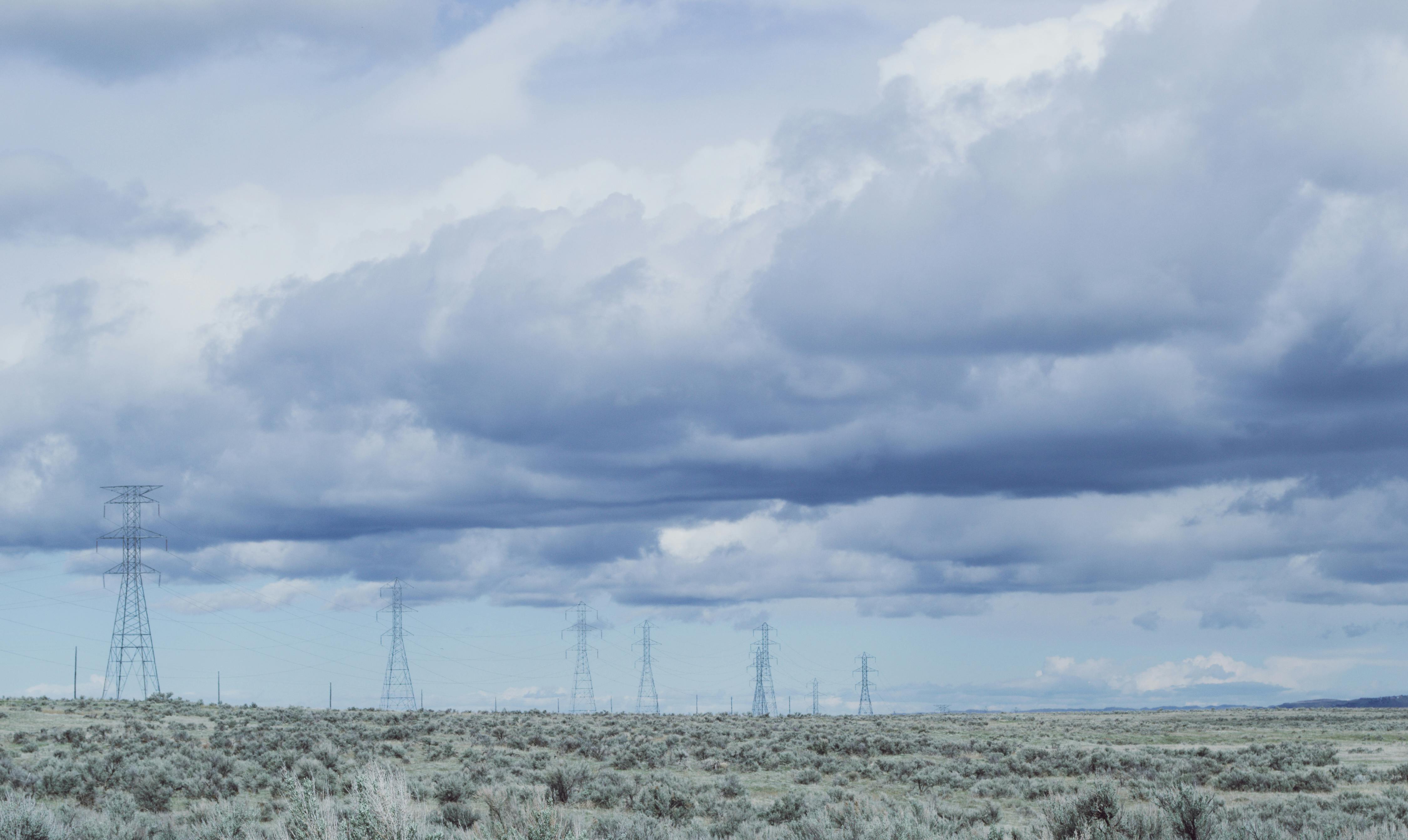 阴沉天空下，电线横跨广阔的乡村