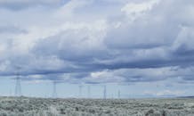 阴沉天空下，电线横跨广阔的乡村