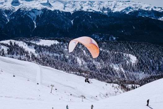 Experience exciting winter paragliding over snow-covered landscapes in Krasnodar, Russia.