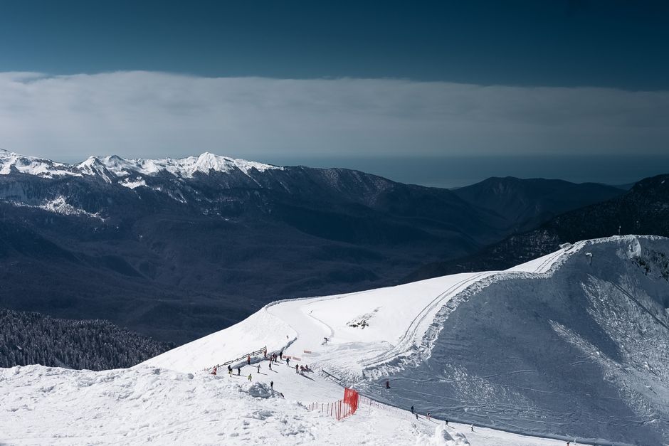 Stunning aerial view of skiers on snow-covered mountains in Krasnodar, Russia.