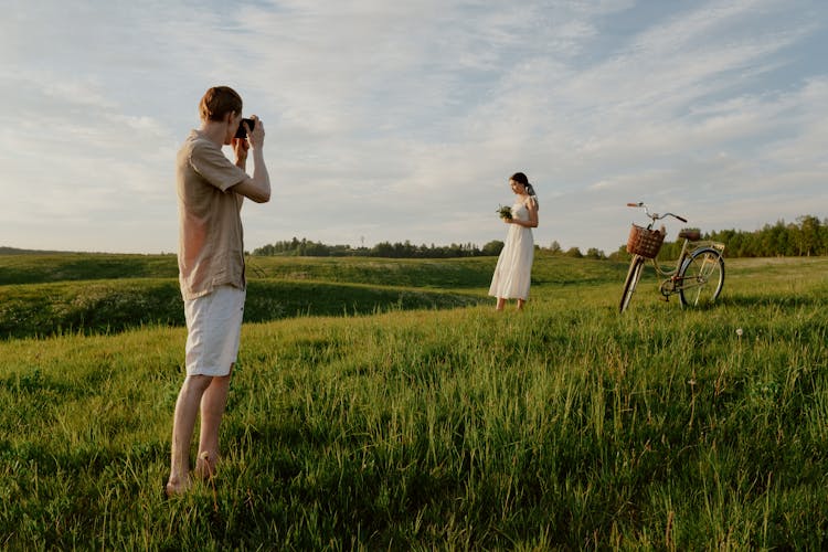 Man Taking Photo Of A Woman And Bicycle