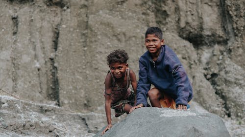 Photograph of Kids Smiling Above a Big Rock