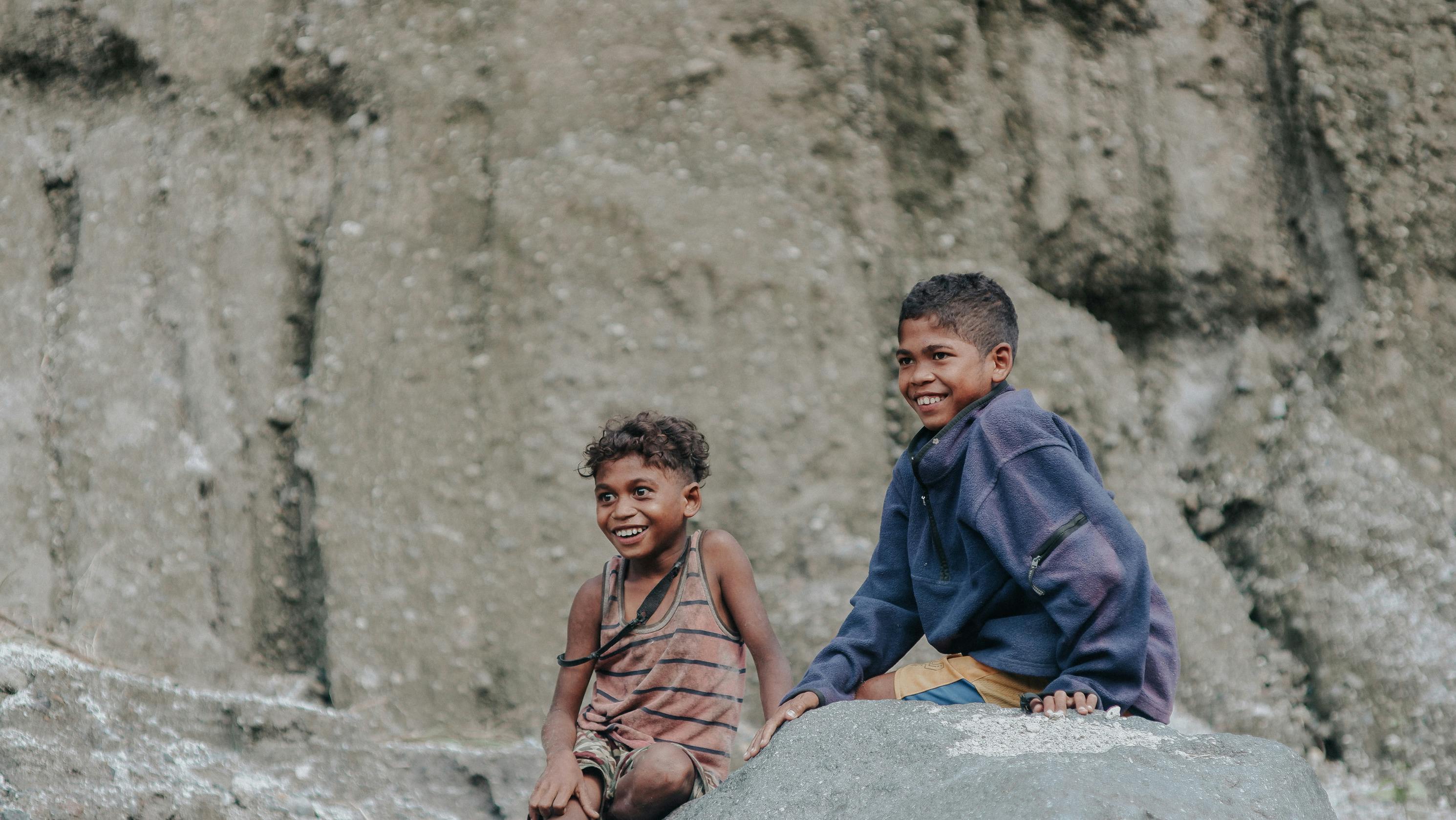 Kids Sitting on Gray Rock · Free Stock Photo