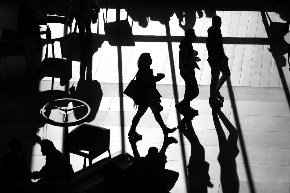 Silueta en blanco y negro de personas caminando, creando sombras impactantes.