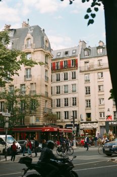 A lively Paris street scene with pedestrians and iconic architecture.