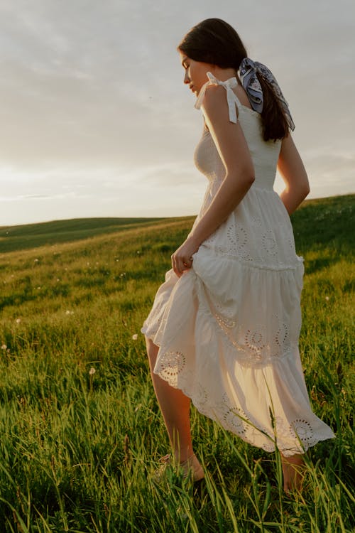 Free Woman in White Dress Walking Through Meadow  Stock Photo
