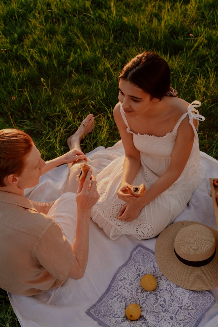 Couple On Picnic Eating Pastries