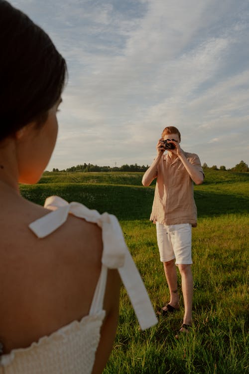 Man Taking Photos of Woman in White Dress