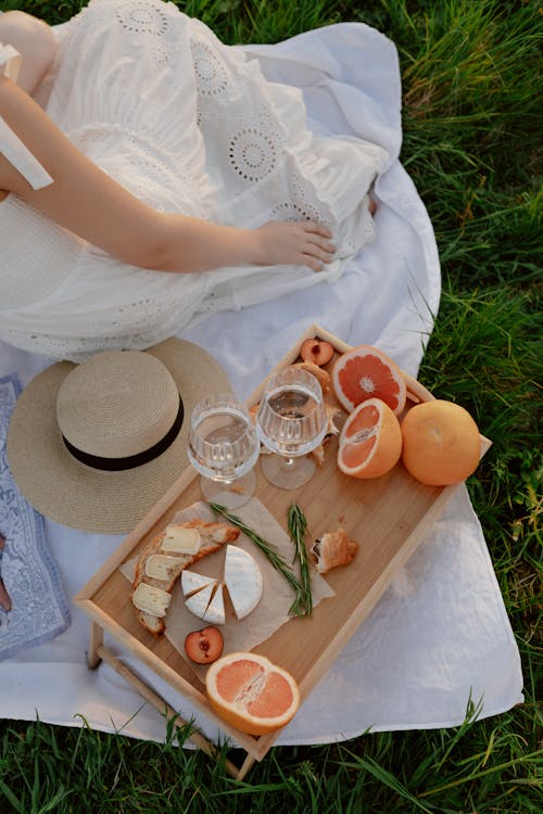 Free Woman Sitting on Blanket with Tray of Grapefruits Stock Photo