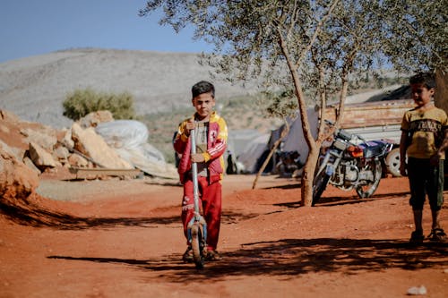 A Boy Standing on Brown Soil