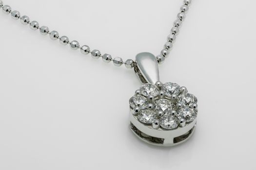 A close-up shot of a luxury diamond pendant necklace with a shiny metallic chain.