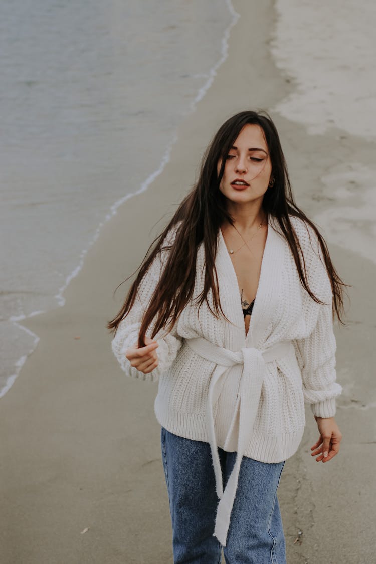 Woman In A White Robe Walking At The Beach